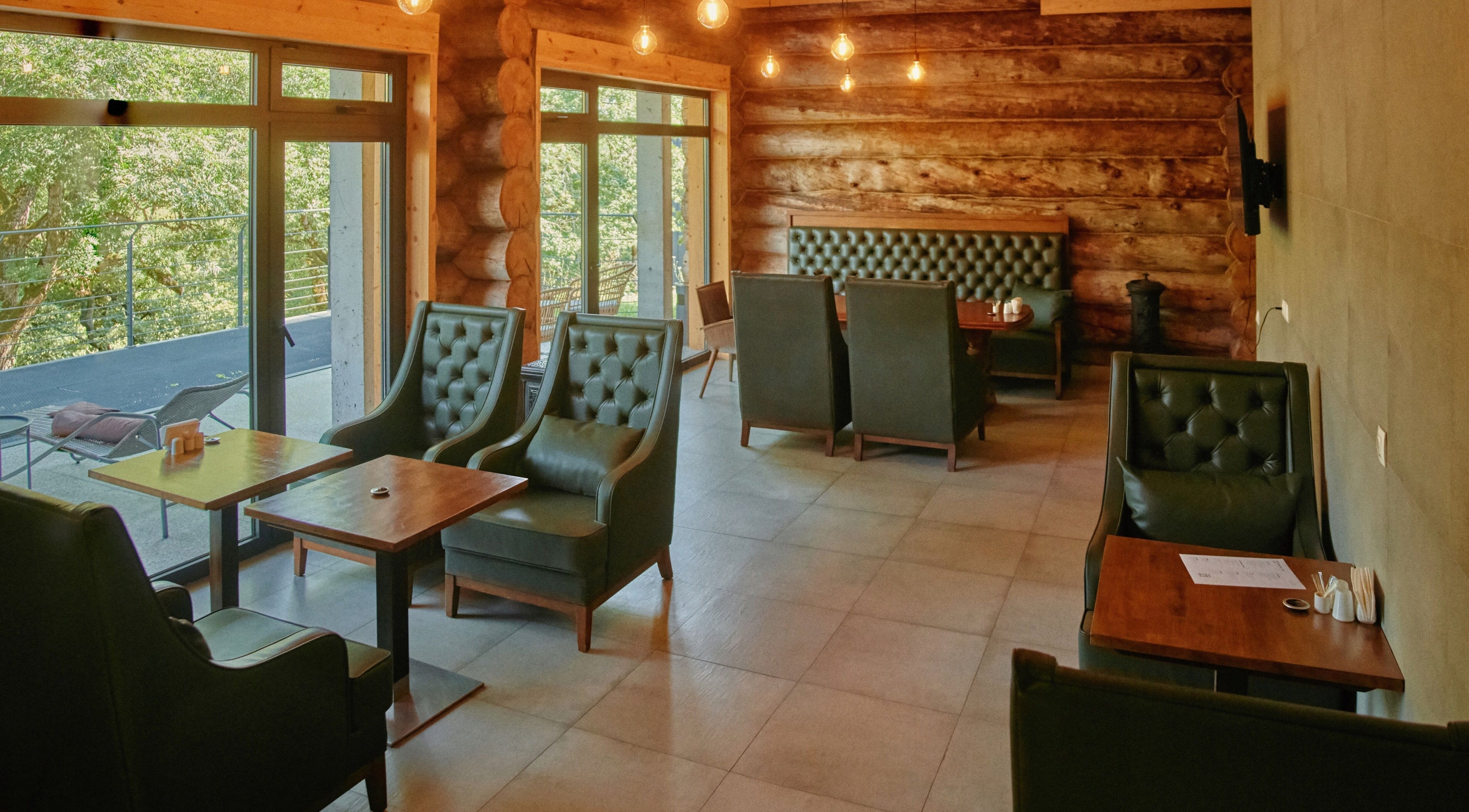 Cozy interior of Banya No.1 - Tbilisi (Public Mixed) in Kiketi, Kvemo Kartli, GE, with leather chairs and log walls.
