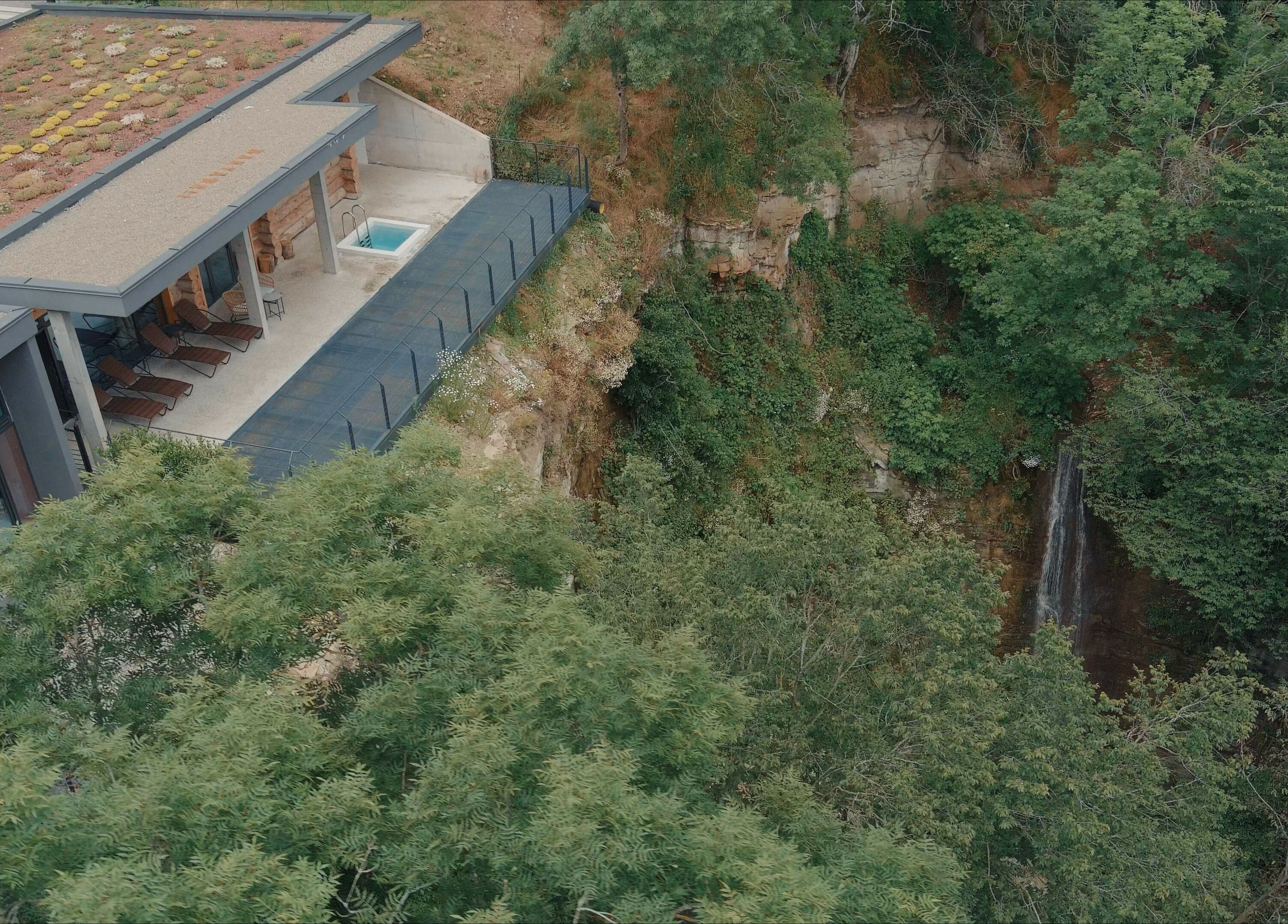 Aerial view of Banya No.1 - Tbilisi (Public Mixed) in Kiketi, Kvemo Kartli, GE, featuring a rooftop terrace by a lush forest.