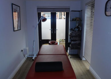 Relaxing massage room at JP Sports Massage in Stockport, England, GB, with massage table and soft lighting.