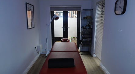 Relaxing massage room at JP Sports Massage in Stockport, England, GB, with massage table and soft lighting.