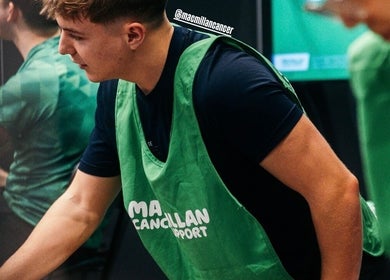 A massage therapist at JP Sports Massage in Stockport, England, GB wearing a green apron during a session.