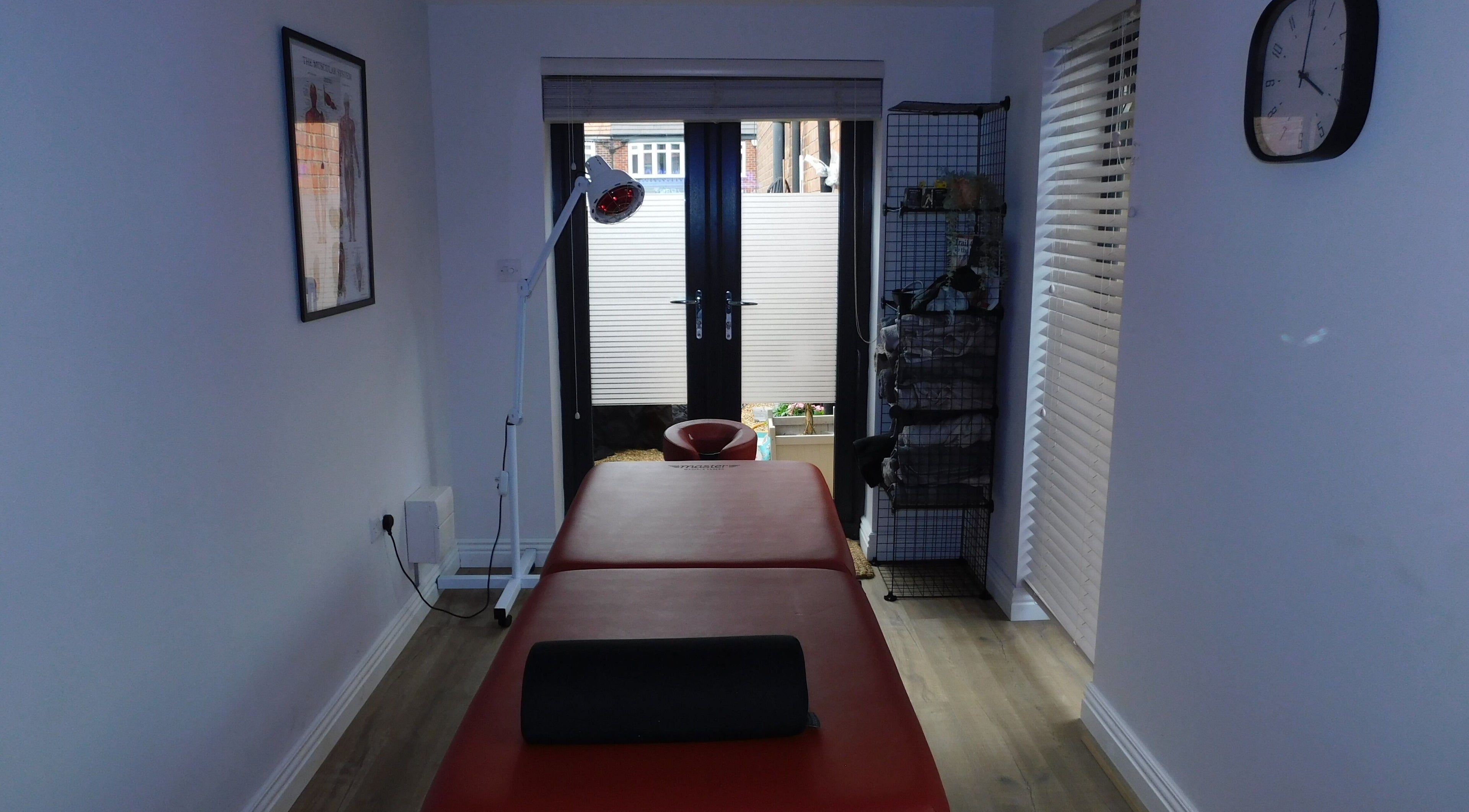 Massage room at JP Sports Massage in Stockport, England, GB, featuring a massage table and ambient lighting.