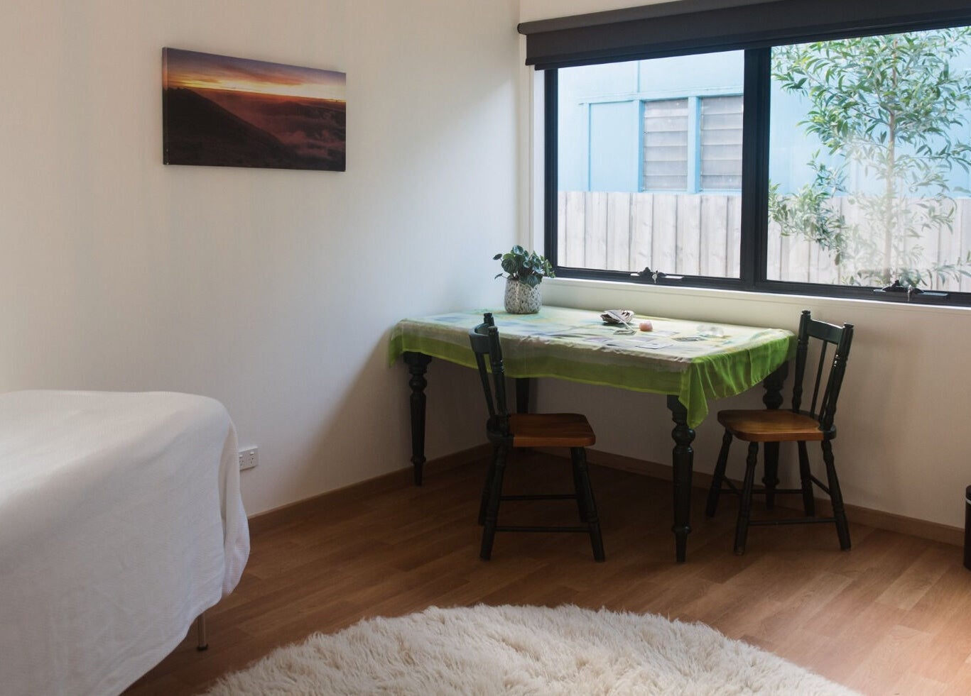 Bright, cozy room at Wildheart Healing, Cygnet, Tasmania, AU with table, chairs, and massage bed.
