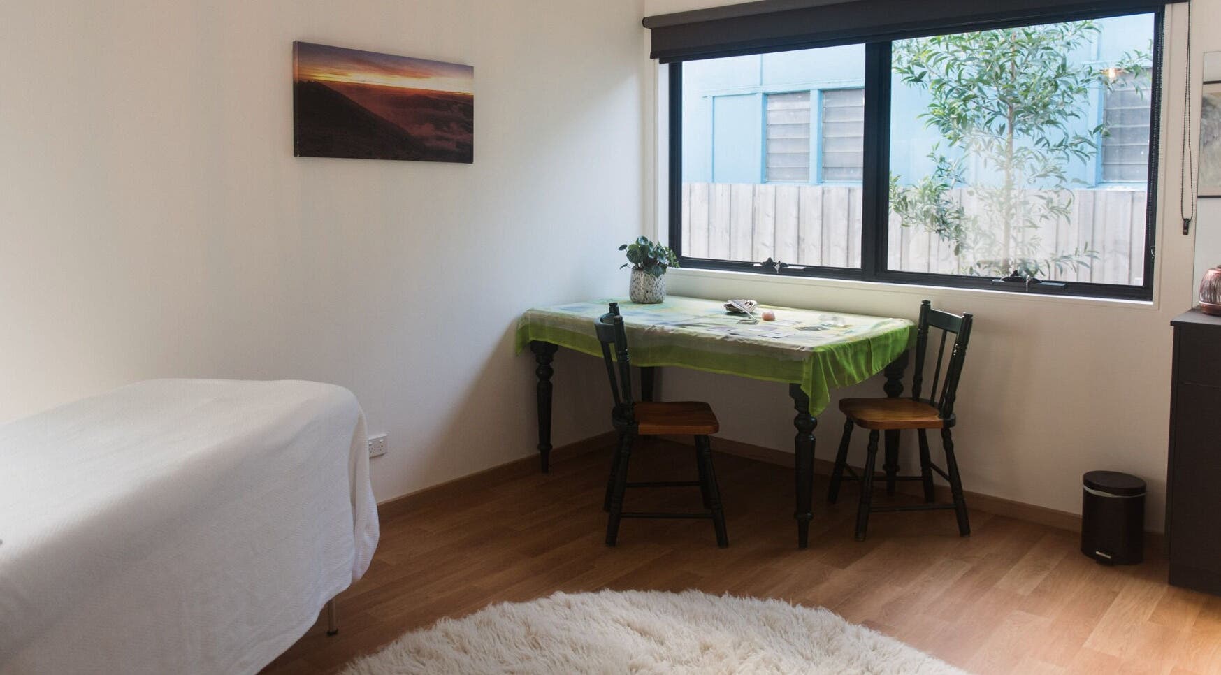 Bright, cozy room at Wildheart Healing, Cygnet, Tasmania, AU with table, chairs, and massage bed.