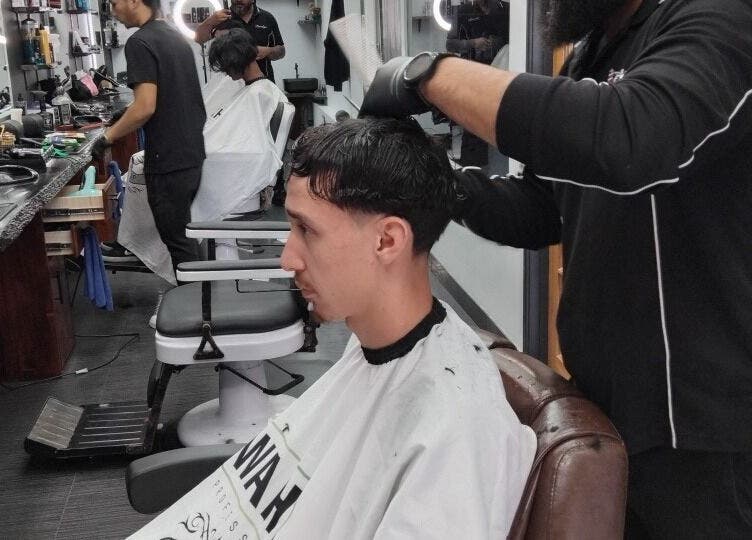 A barber skillfully cutting hair at Prestige Barber Lounge Caversham, Western Australia, AU.