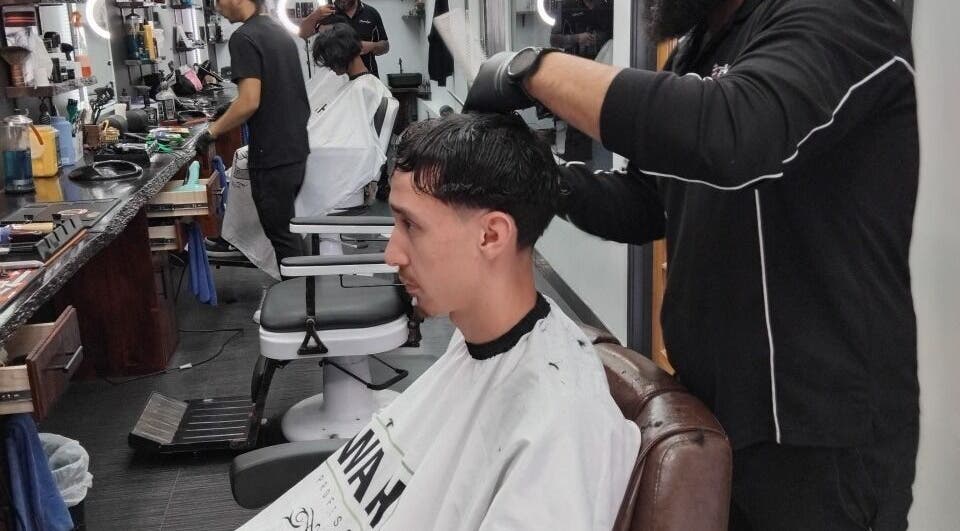 A barber skillfully cutting hair at Prestige Barber Lounge Caversham, Western Australia, AU.