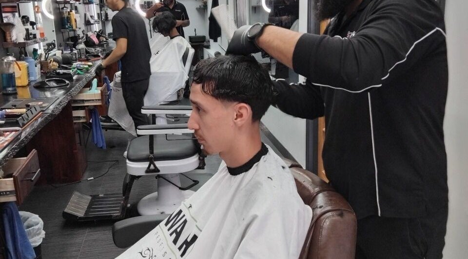 A barber skillfully cutting hair at Prestige Barber Lounge Caversham, Western Australia, AU.