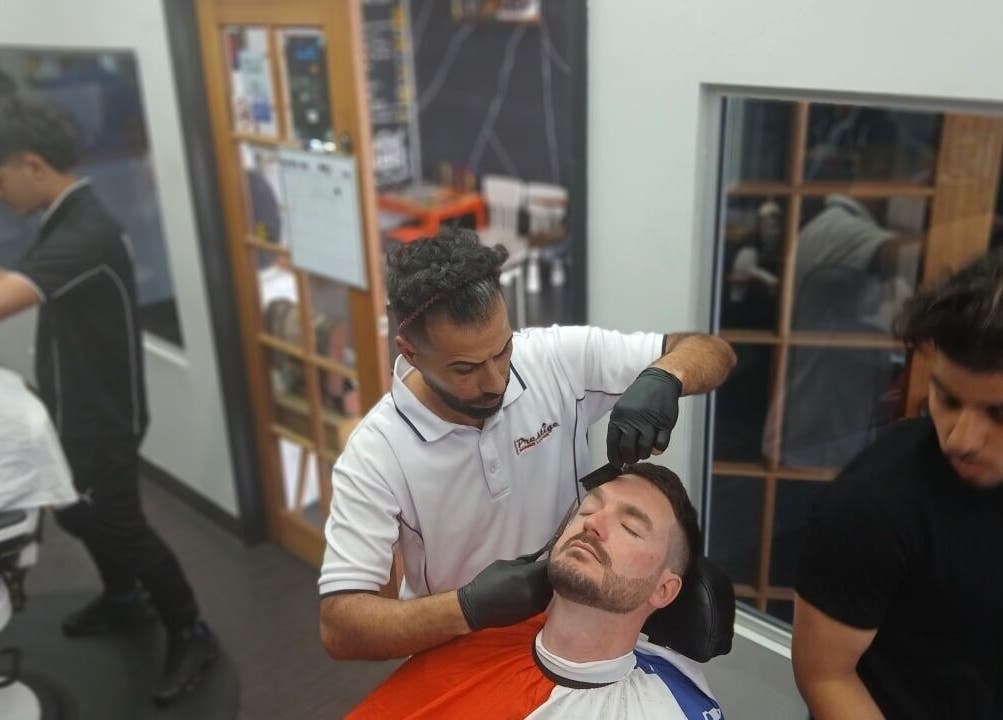 Barbers at Prestige Barber Lounge Caversham, Caversham, Western Australia expertly groom a client's beard.