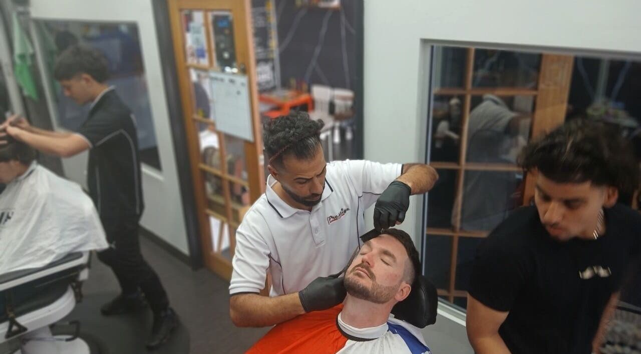 Barbers at Prestige Barber Lounge Caversham, Caversham, Western Australia expertly groom a client's beard.