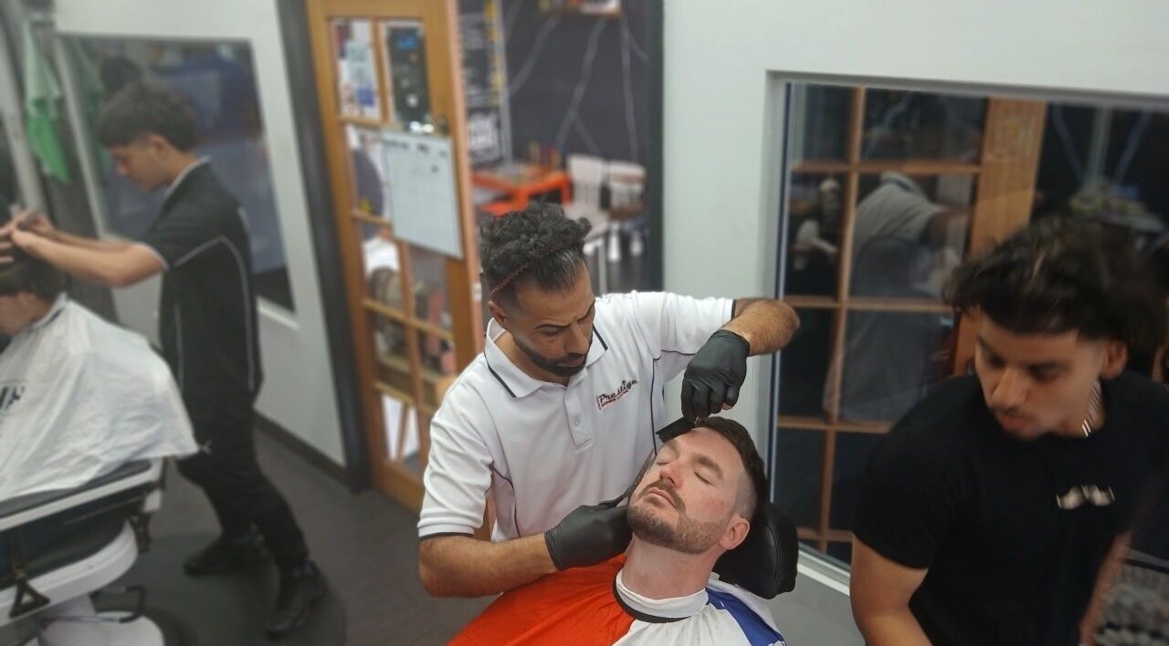 Barbers at Prestige Barber Lounge Caversham, Caversham, Western Australia expertly groom a client's beard.