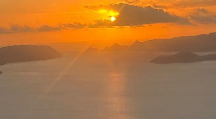 Breathtaking sunset view near Afterglow Skin & Tan, Kerikeri, Northland, NZ showcasing serene waters and mountains.