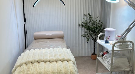 Tranquil treatment room at Houseofbeauty, London, England, GB with cozy bed and plant for relaxation.
