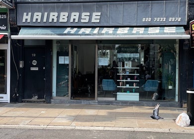 Front view of Houseofbeauty salon in London, England, GB with a modern glass facade and street reflections.