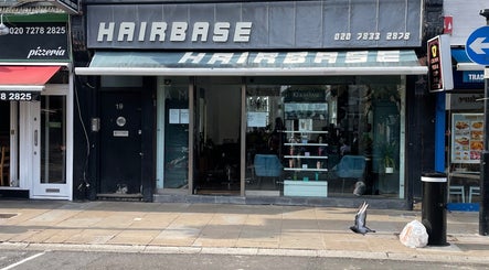 Front view of Houseofbeauty salon in London, England, GB with a modern glass facade and street reflections.