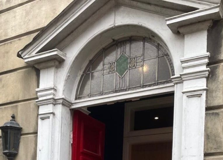 Charming vintage entrance at Nail by Lils, Tamworth, England, GB with a red door and decorative arch.