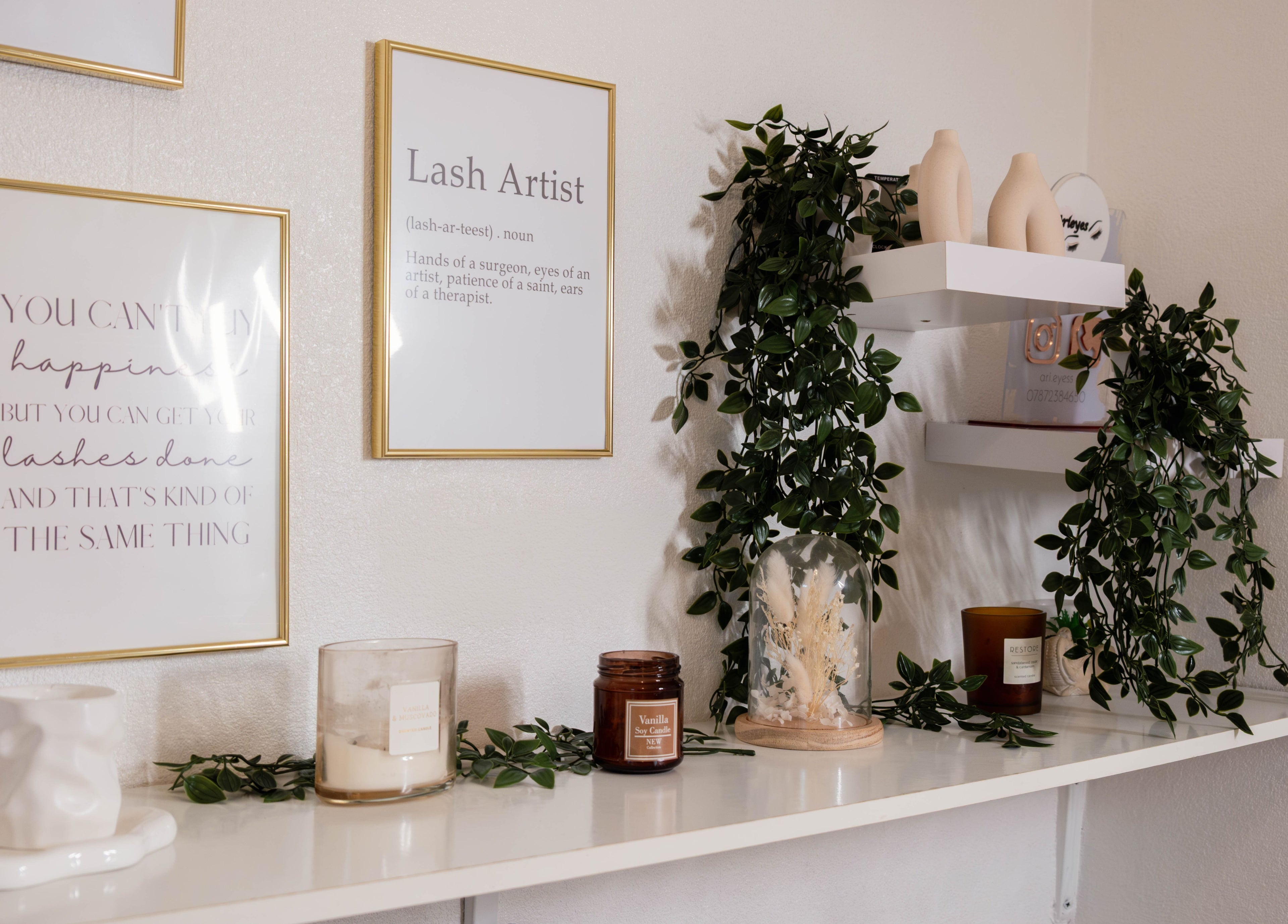 Stylish wall decor at Arieyes, London, England, GB with gold frames and lush greenery.