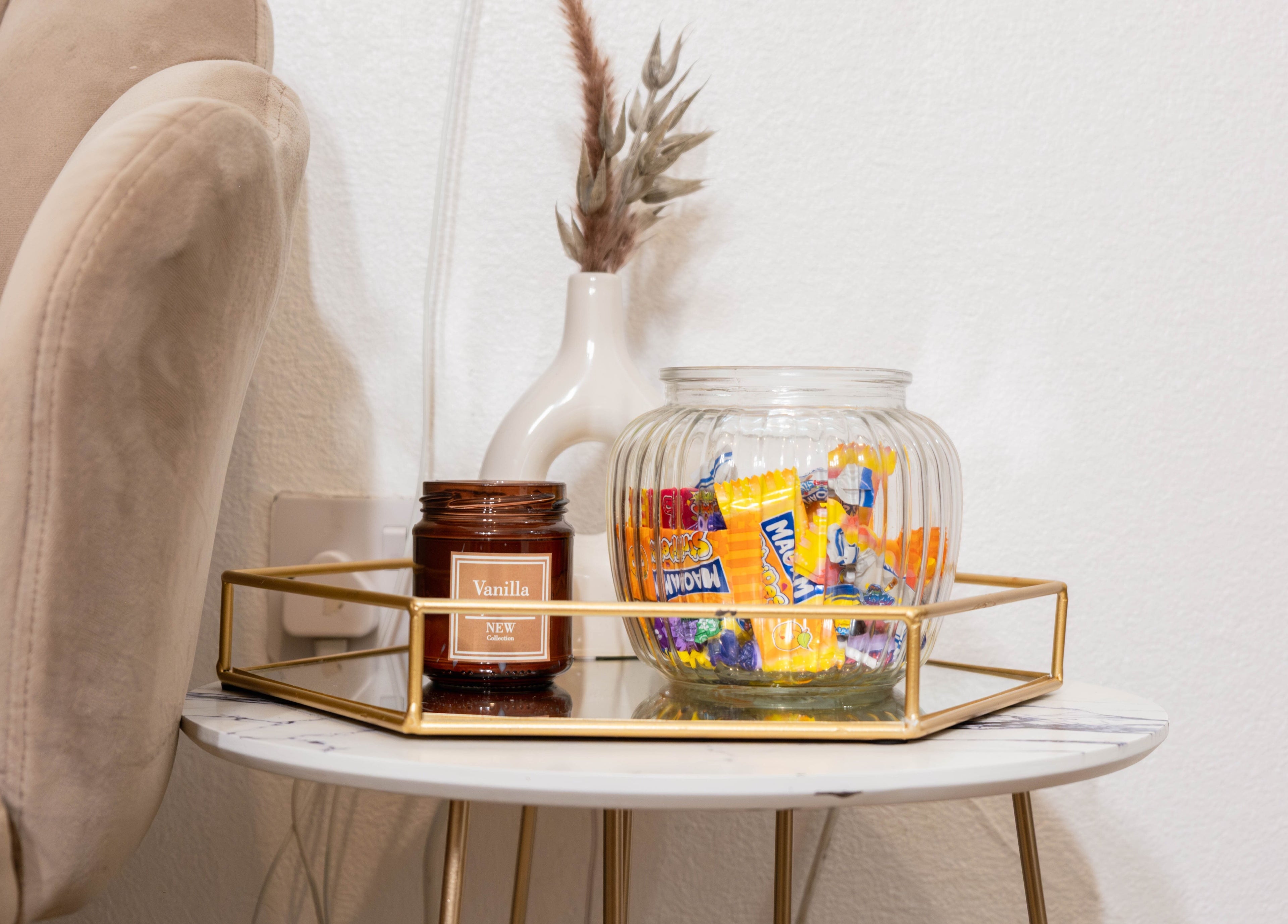 Stylish table with decor at Arieyes, London, England, GB. Features glass jar and vanilla candle.