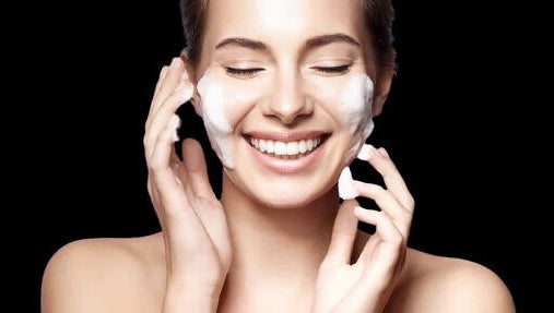 Mujer aplicando crema facial en Shine Spa, San Lorenzo, Puerto Rico, US.