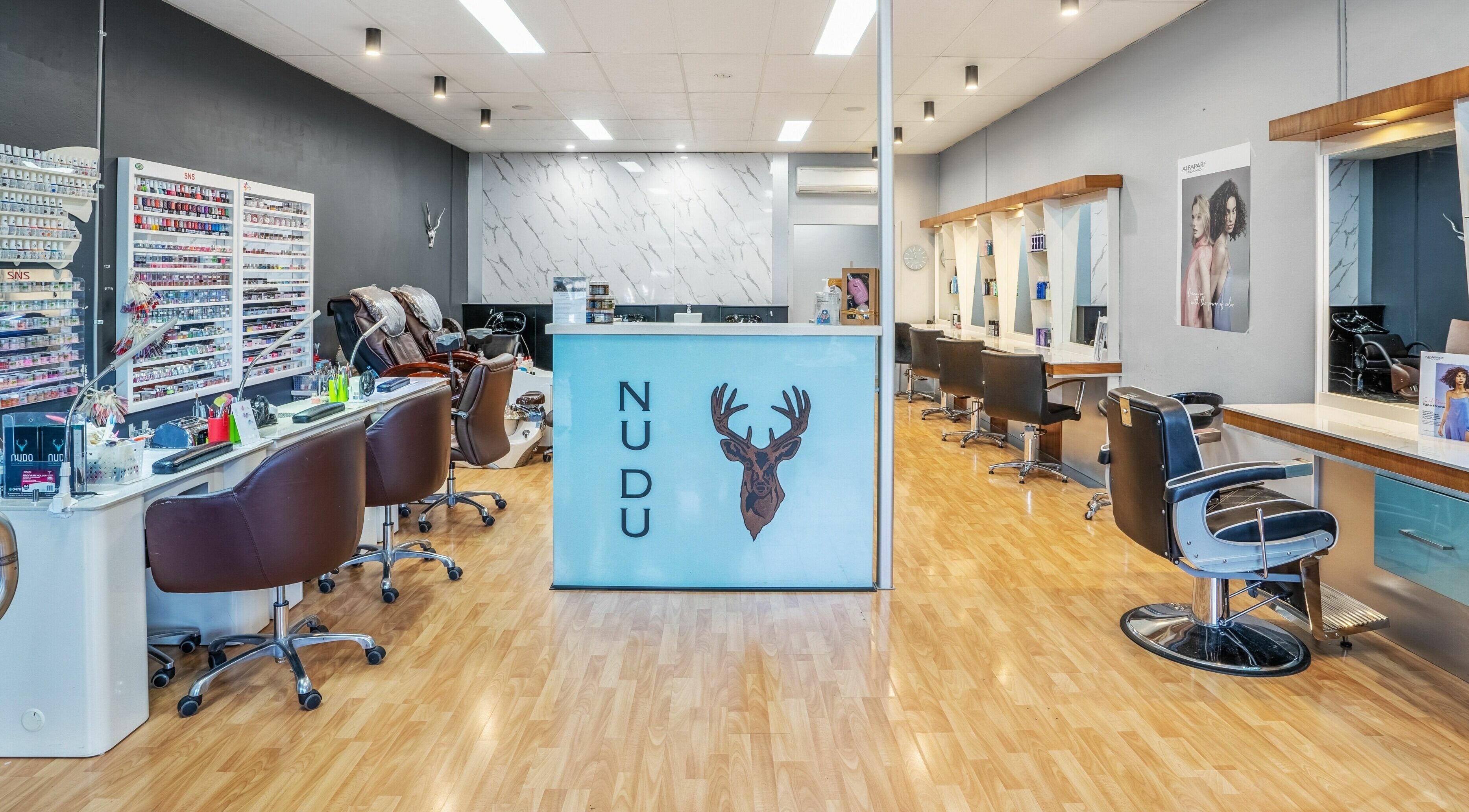 Modern interior of Nudo Nails and Beauty in Melbourne, Victoria, AU, showcasing sleek styling stations and nail polishes.