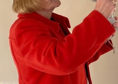 Warm greeting at Vixi Wellbeing Hub, Darlington, England, GB with guest in vivid red coat.