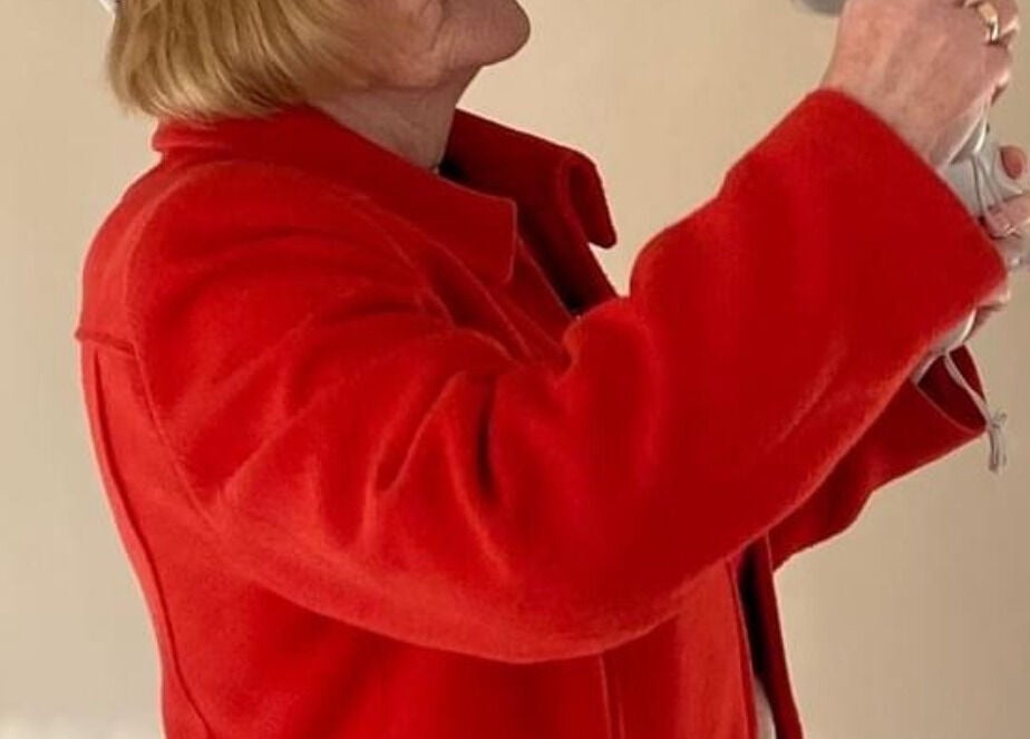 Warm greeting at Vixi Wellbeing Hub, Darlington, England, GB with guest in vivid red coat.