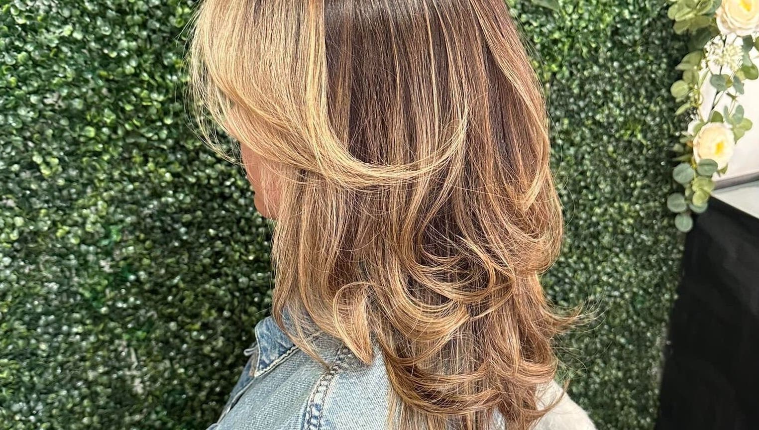 Beautiful layered hairstyle at Concept Dominican Hair Studio, West Palm Beach, Florida, US, on a green backdrop.