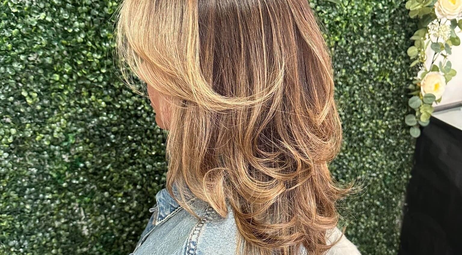 Beautiful layered hairstyle at Concept Dominican Hair Studio, West Palm Beach, Florida, US, on a green backdrop.