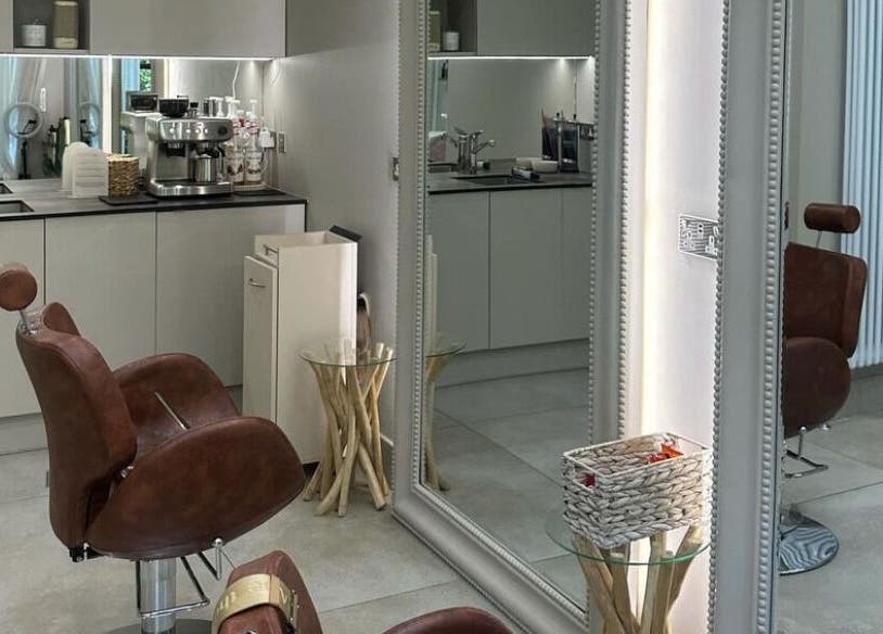 Stylish salon interior at Grace Waker Hair in Oakley, England, GB, featuring cozy brown chairs and modern decor.