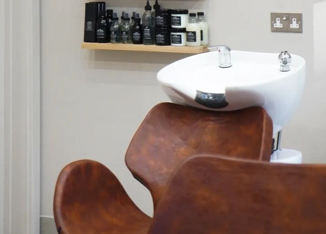 Luxurious wash basin at Grace Waker Hair, Oakley, England, GB. Premium haircare products displayed on a shelf.