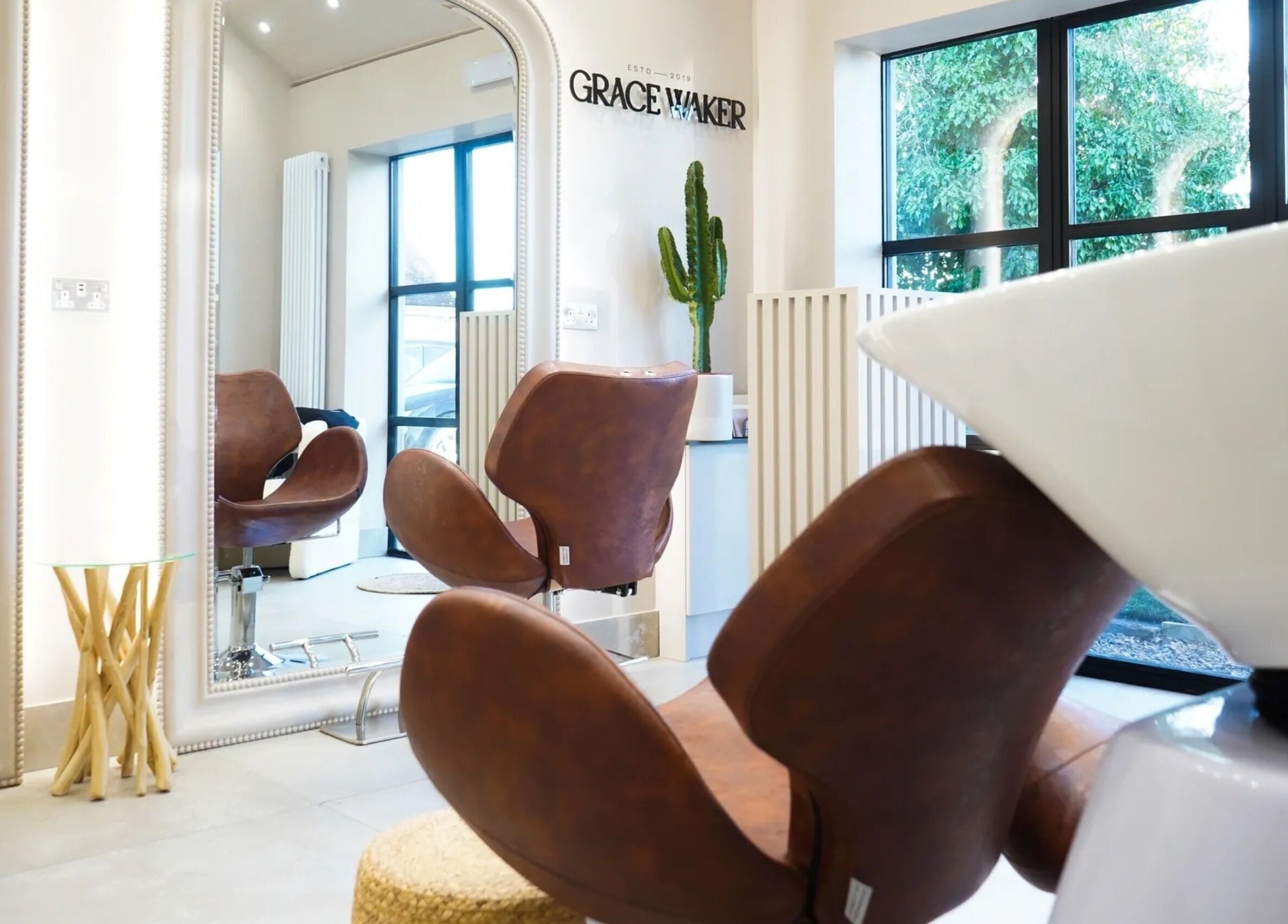 Grace Waker Hair salon in Oakley, England, GB features stylish brown chairs under bright natural light.