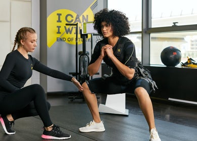 Personal training session at Justfit EMS Dubai, Dubai, AE. Two women engaging in a workout with EMS suits.
