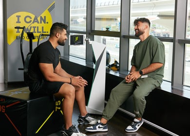 Two men converse at Justfit EMS Dubai, Dubai, AE, enhancing wellness with cutting-edge equipment.