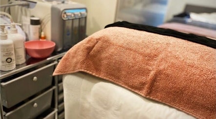 Acenti Skin spa bed with peach towel in London, England, GB, ready for a relaxing session.