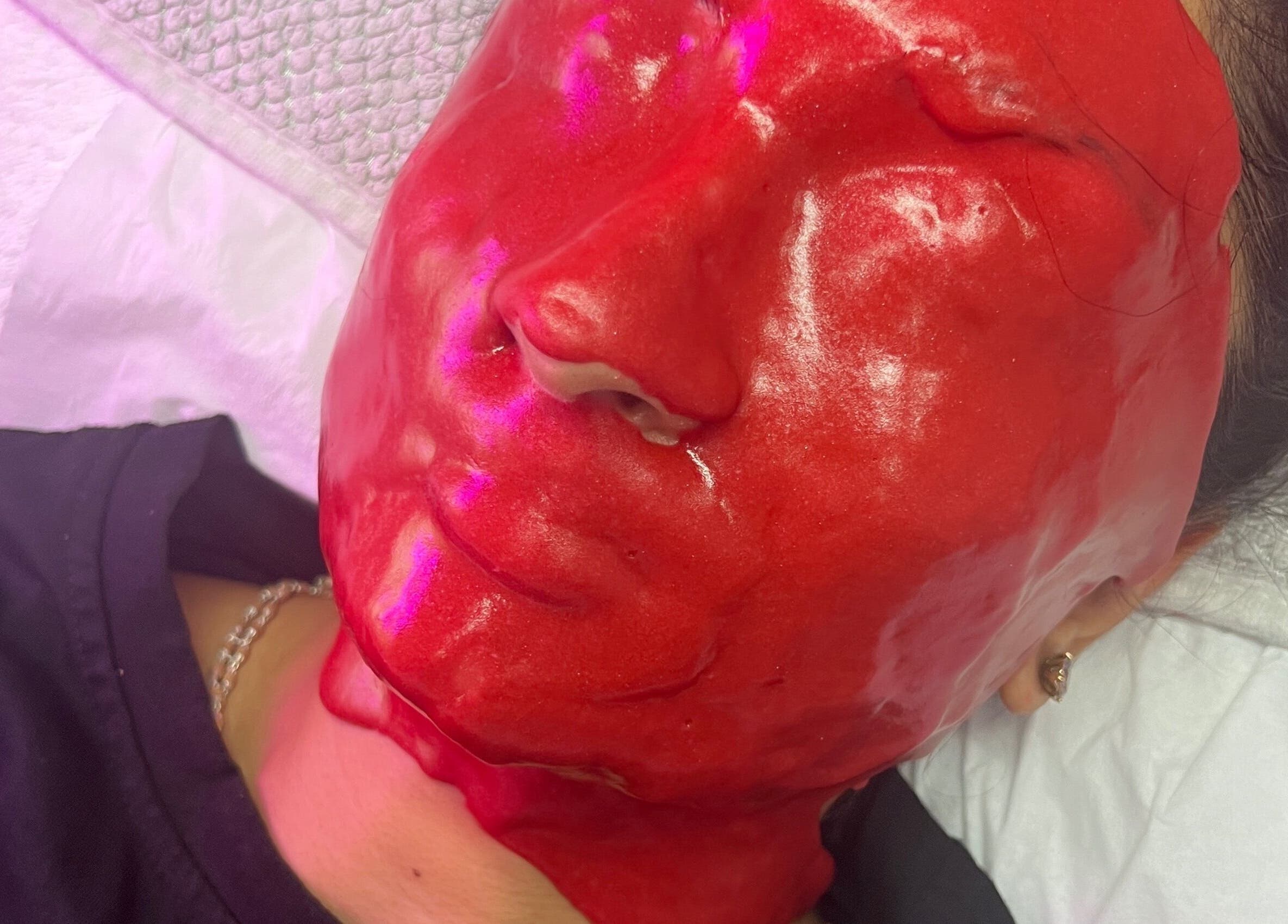 Bright red facial mask at The Facial Bar in North London, England, GB enhances skin care experience.