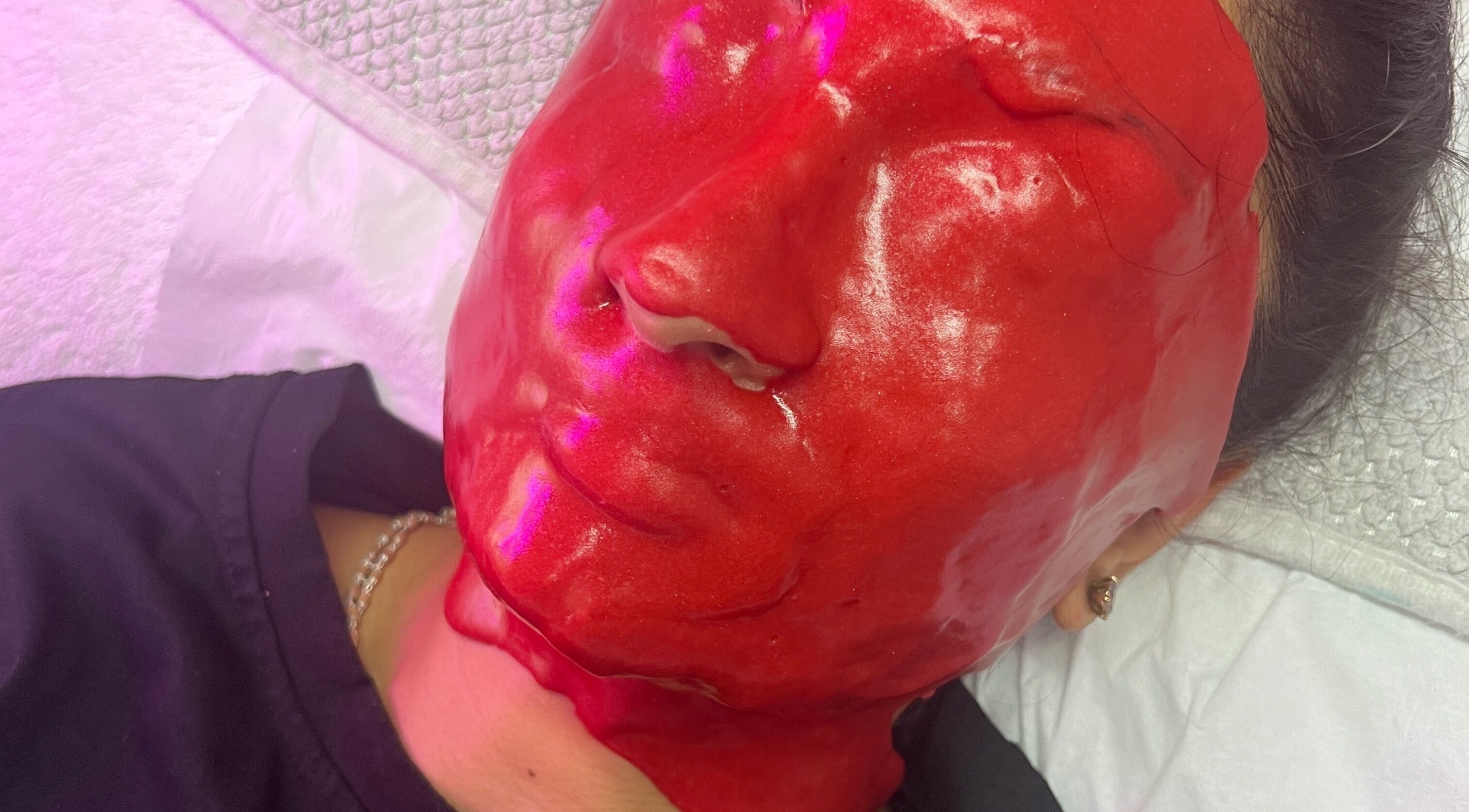 Bright red facial mask at The Facial Bar in North London, England, GB enhances skin care experience.