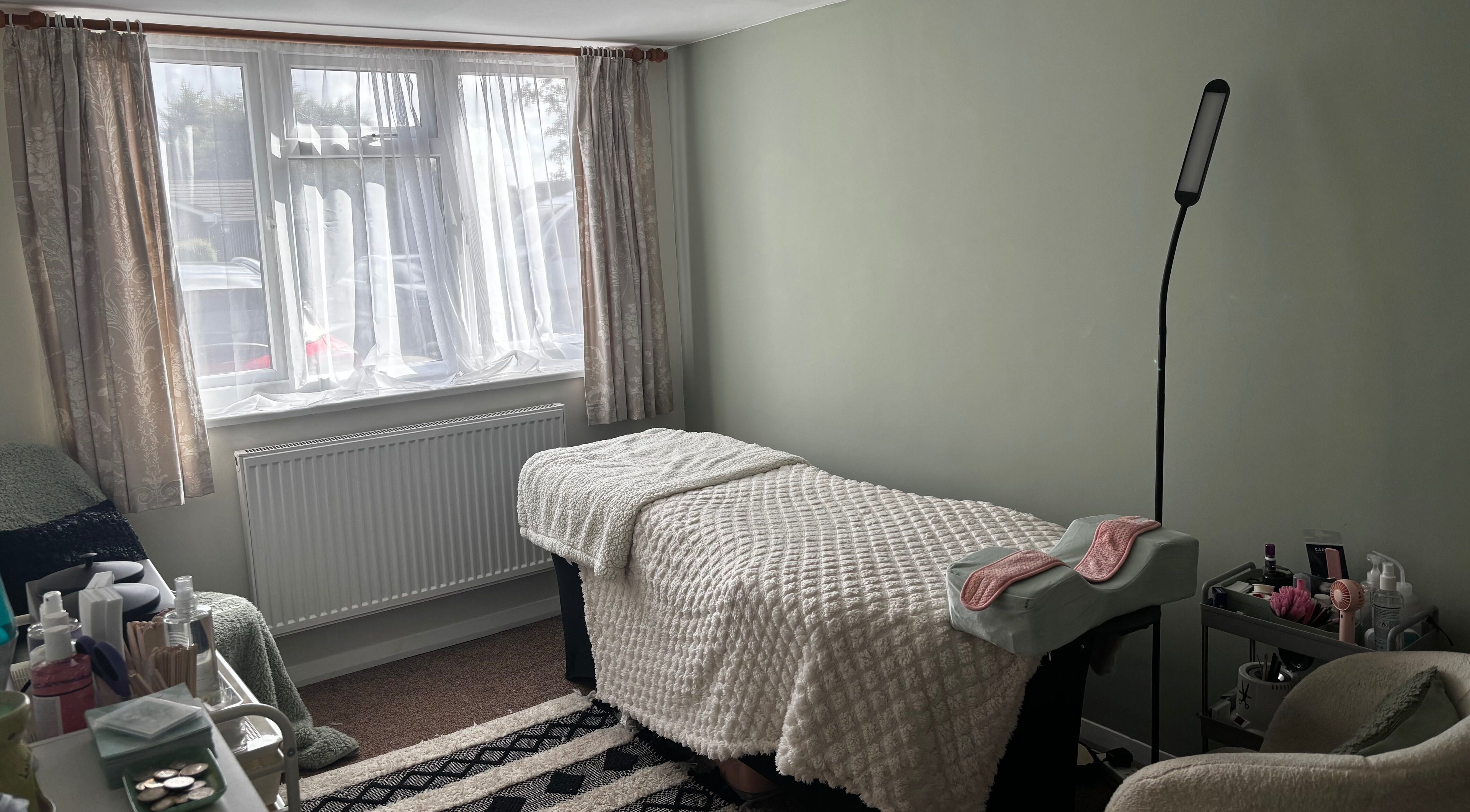 Cozy therapy room at Megan Ellen Beauty in Rushmere Saint Andrew, England, GB, featuring a treatment bed.