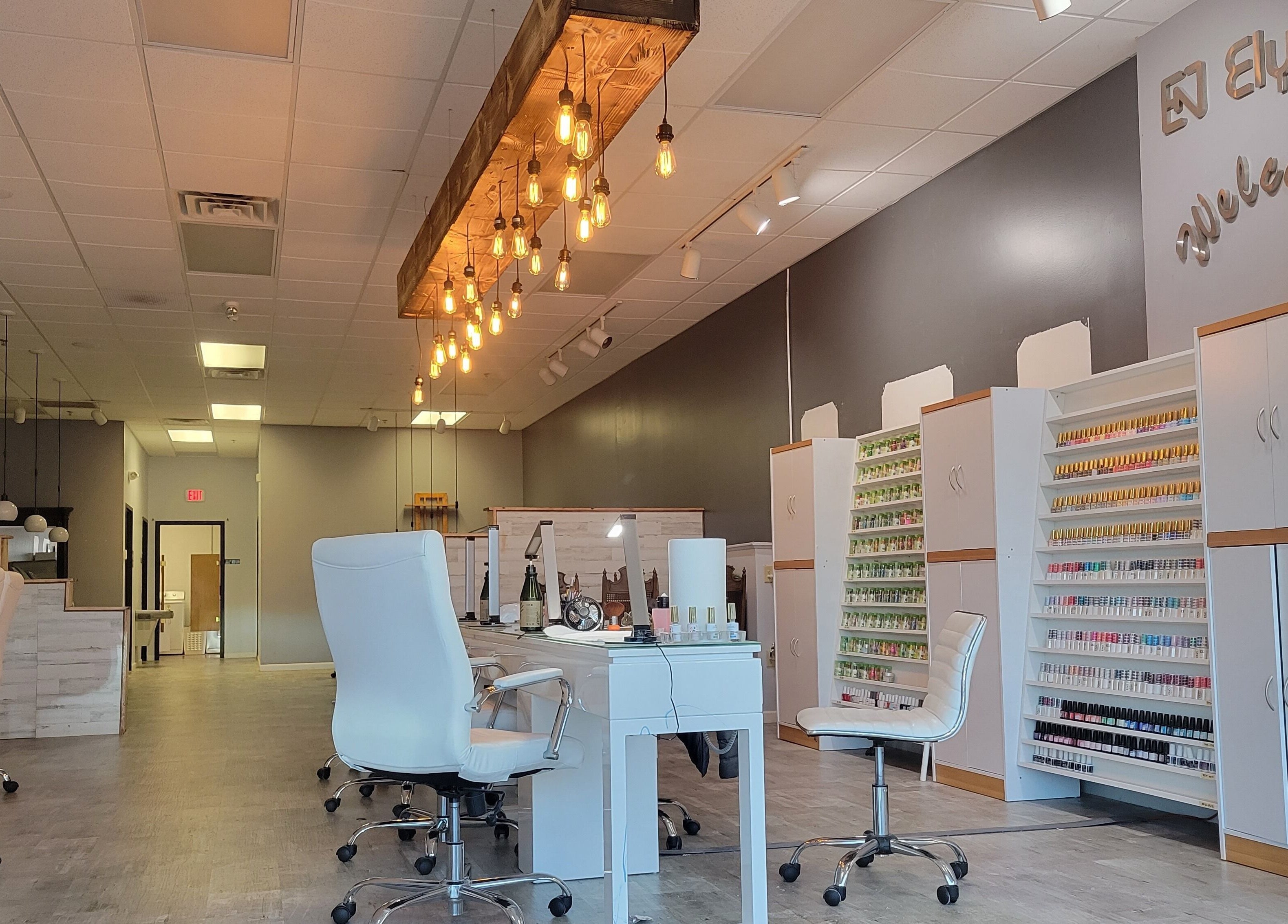 Modern interior of Elysian Nails in Neenah, Wisconsin, US, featuring sleek chairs and nail polish displays.