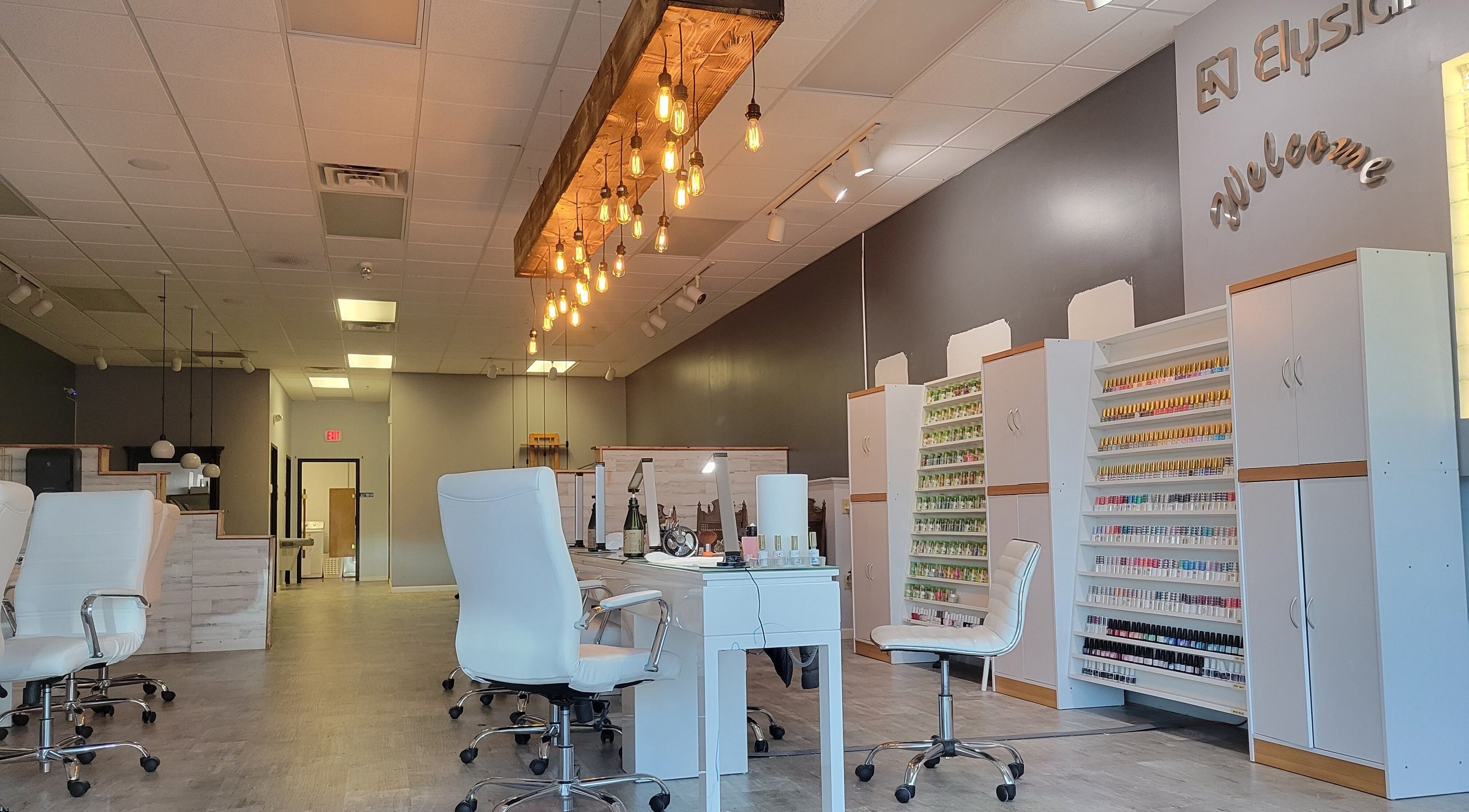 Modern interior of Elysian Nails in Neenah, Wisconsin, US, featuring sleek chairs and nail polish displays.