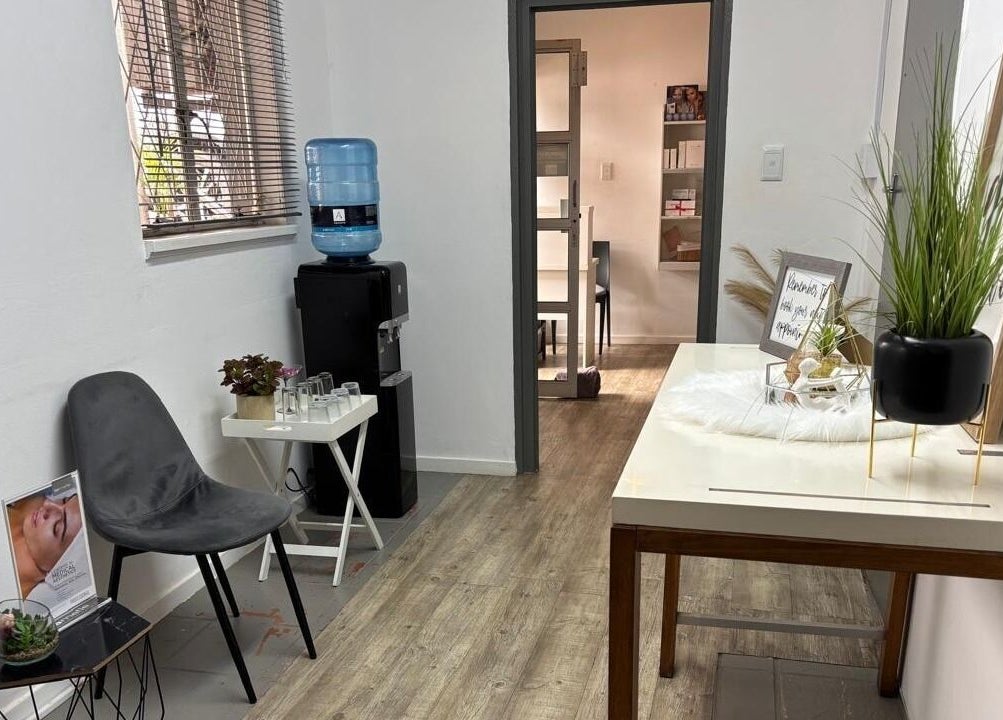 Relaxing waiting area at Made up by Mariam, Hillcrest, Kwazulu-natal, ZA with chairs, decor, and a water dispenser.