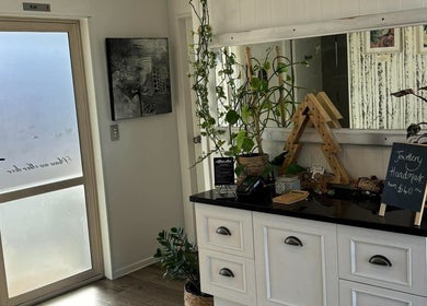 Entrance of Trish Strike beauty in Tauranga, Bay of Plenty, NZ featuring chic decor and calming plants.