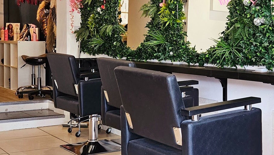 Elegant salon chairs and lush green decor at Hair at O’Neills, Fareham, England, GB.