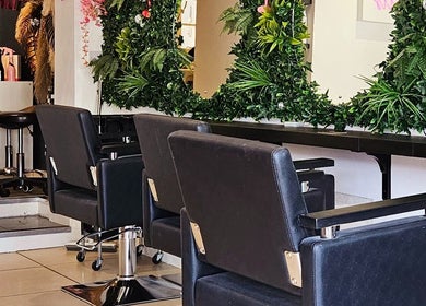 Elegant salon chairs and lush green decor at Hair at O’Neills, Fareham, England, GB.