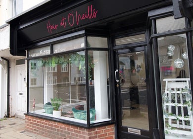 Front view of Hair at O’Neills, Fareham, England, GB showcasing stylish black storefront.