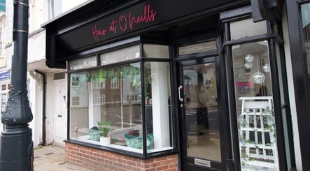 Front view of Hair at O’Neills, Fareham, England, GB showcasing stylish black storefront.