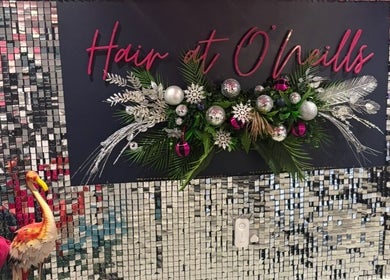 Festive decor at Hair at O’Neills, Fareham, England, GB with silver tiles and vibrant centerpiece.