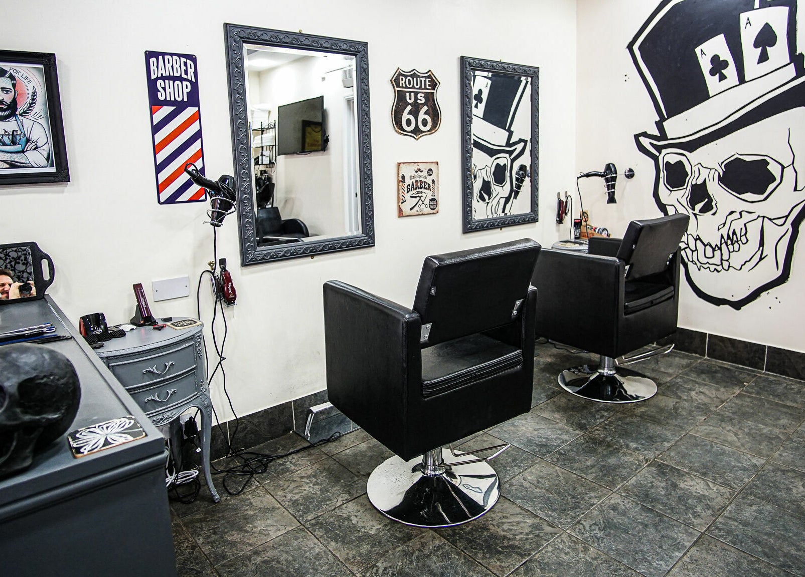 Interior of Aces Barbershop, featuring stylish skull art and mirrors in Northampton, England, GB.