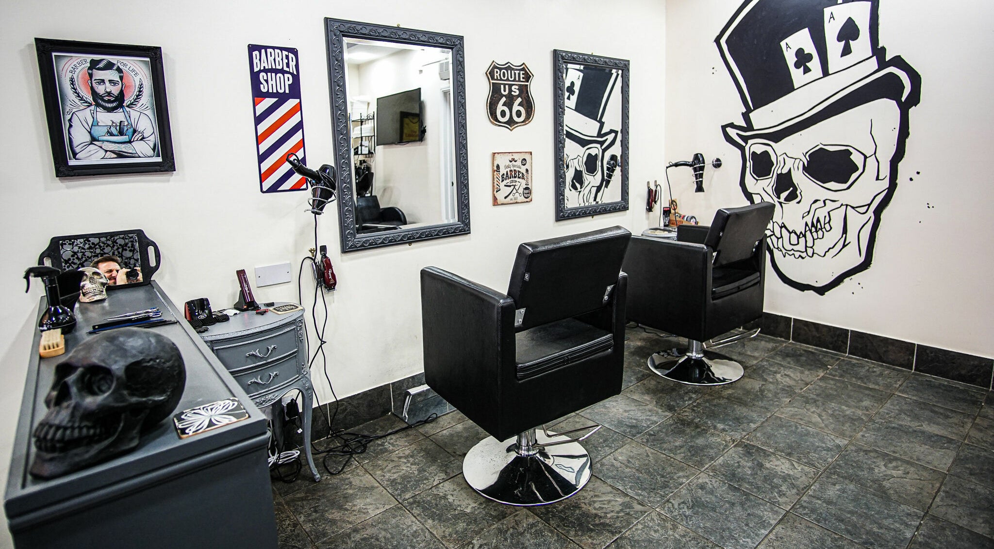Interior of Aces Barbershop, featuring stylish skull art and mirrors in Northampton, England, GB.