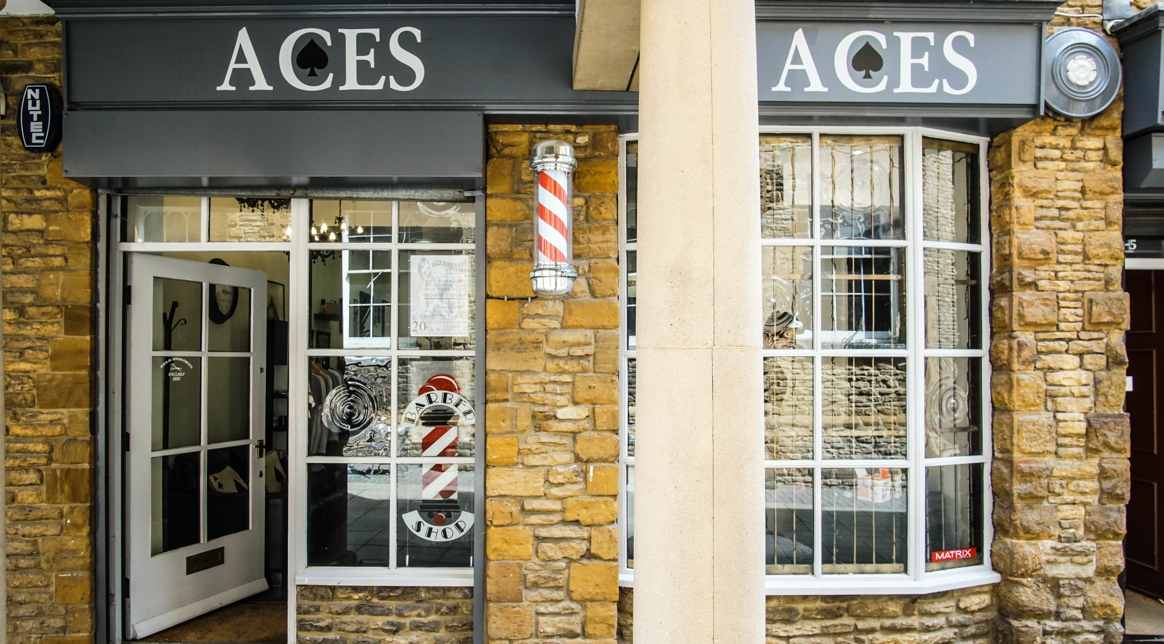 Entrance to Aces Barbershop, College St Mews, Northampton, showcasing its elegant exterior. Located in Northampton, England, GB.