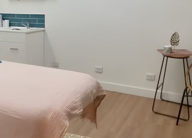 Tranquil treatment room at Nudie Skin Studio, Melbourne, Victoria, AU with soft pink linen and modern decor.