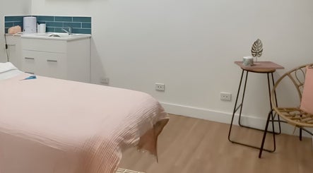 Tranquil treatment room at Nudie Skin Studio, Melbourne, Victoria, AU with soft pink linen and modern decor.